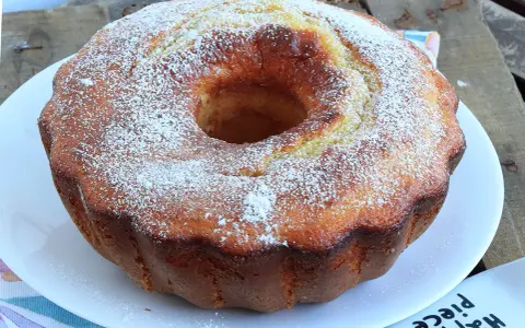 Ciambella soffice allo yogurt greco, cosparsa di zucchero a velo, pronta per essere gustata.