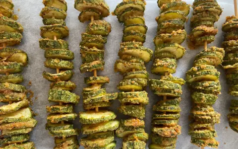 Spiedini di zucchine al forno, dorati e croccanti, pronti per essere gustati.
