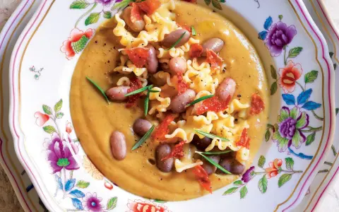 Un piatto invitante di pasta e fagioli, con pasta riccia, fagioli borlotti, pomodori secchi e rosmarino. La ricetta originale è un classico confortante.