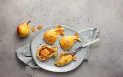 Pasticcini salati a forma di pesce, uno aperto rivela un ripieno cremoso. Un'idea originale per le tue ricette con le pere.