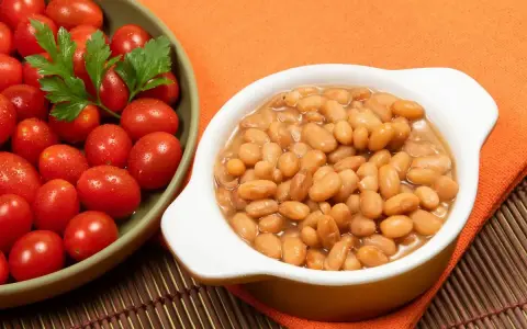 Fagioli secchi in umido, pronti per essere gustati. Scopri come cucinare i fagioli secchi per un piatto saporito, accompagnati da pomodorini freschi.