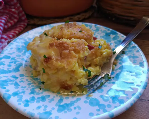 Sformato di riso dorato e filante, servito su un piatto con decorazioni blu. Un piatto invitante e gustoso.