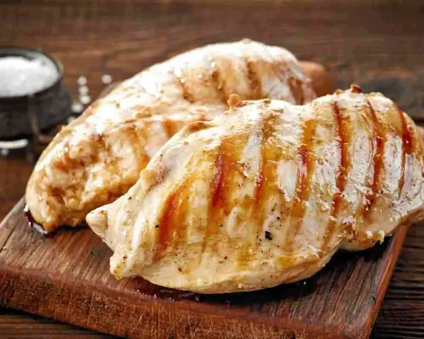 Petto di pollo grigliato, perfetti secondi di carne da preparare in anticipo. Un contorno di sale completa l'immagine.