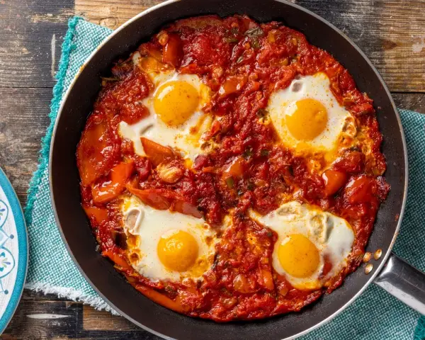 Uova in purgatorio in padella, un classico tra le ricette con uova, con pomodoro e peperoni.
