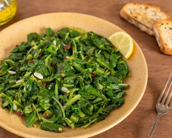 Cicoria saltata con aglio e peperoncino, un modo semplice per imparare come cucinare la cicoria. Servita con pane tostato e limone.