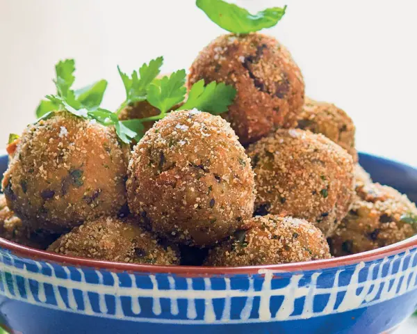 Polpette dorate e croccanti, perfette per le tue ricette con melanzane. Guarnite con prezzemolo e basilico fresco.