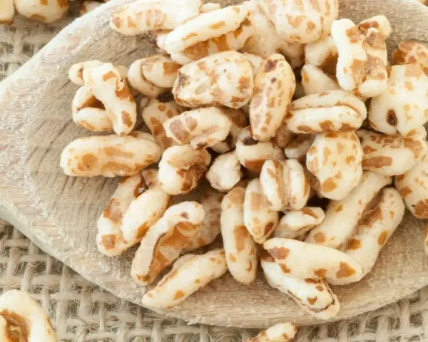 Farro soffiato su un cucchiaio di legno, perfetto per colazioni leggere e ricette creative.