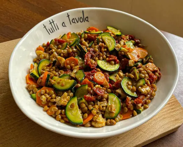 Insalata di lenticchie con zucchine, carote e pomodori secchi, perfetta per le ricette estive.