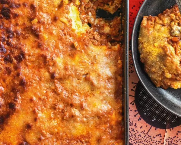 Una porzione di lasagna al ragù appena sfornata, dorata e invitante, pronta per essere gustata.