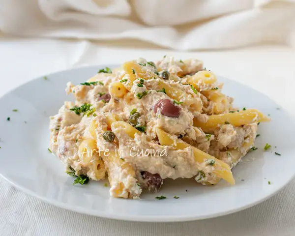 Piatto di pasta cremosa con tonno, capperi e olive taggiasche, guarnito con prezzemolo fresco.