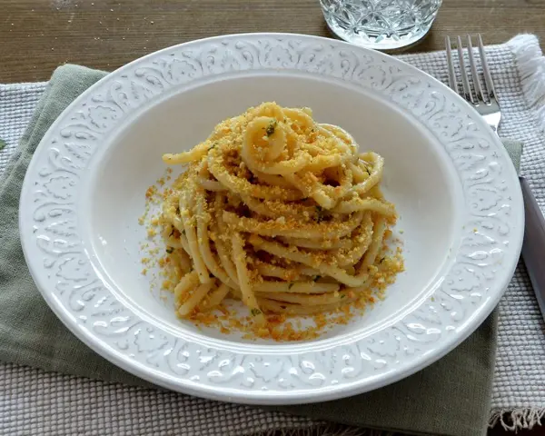 Pasta con pangrattato e acciughe alla siciliana, un piatto semplice ma ricco di sapore, pronto per essere gustato.