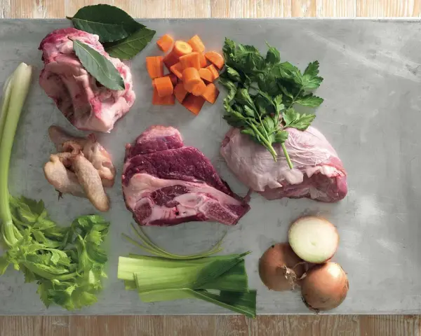 Ingredienti per un brodo saporito: carne per brodo, carote, sedano, cipolle, prezzemolo e alloro.