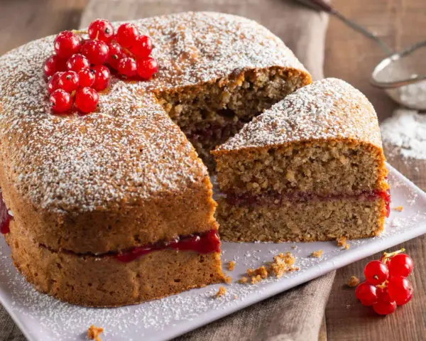 Torta di grano saraceno soffice, farcita con marmellata e decorata con ribes rossi e zucchero a velo.