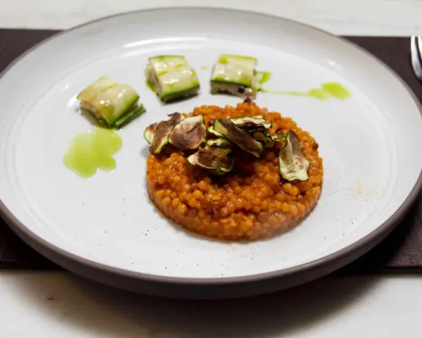 Piatto di fregola sarda ricette con zucchine croccanti e salsa verde. Un primo piatto gustoso e colorato.