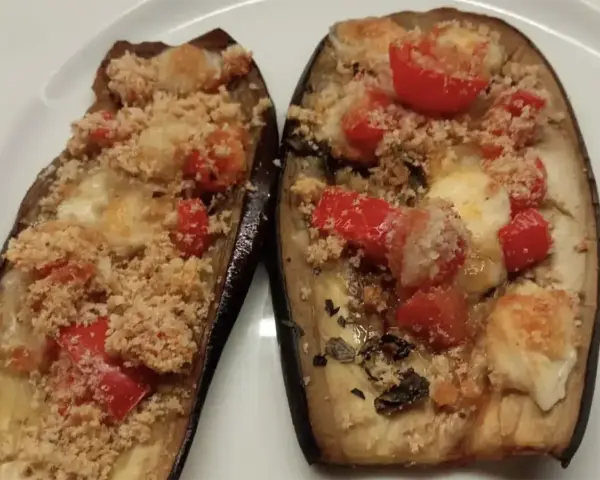 Melanzane ripiene al forno, un'idea per ricette sfiziose con pomodorini e formaggio filante.