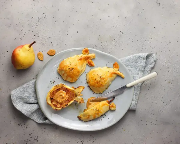 Pasticcini salati a forma di pesce, uno aperto rivela un ripieno cremoso. Un'idea originale per le tue ricette con le pere.