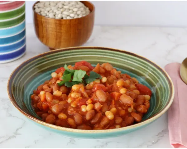 Un piatto invitante di fagioli in umido, con pomodoro e prezzemolo fresco, pronto per essere gustato.