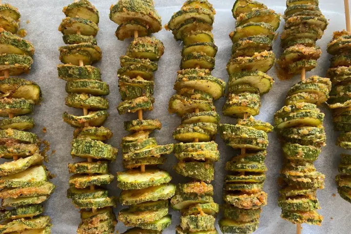 Spiedini di zucchine al forno, dorati e croccanti, pronti per essere gustati.