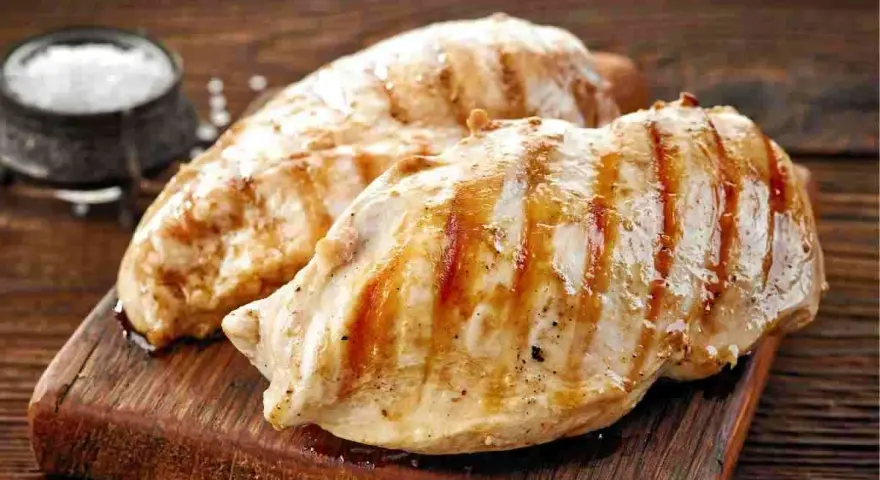 Petto di pollo grigliato, perfetti secondi di carne da preparare in anticipo. Un contorno di sale completa l'immagine.