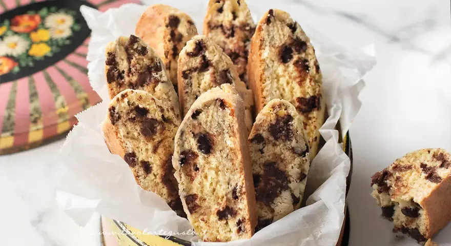 Biscotti con frutta secca, croccanti e golosi, serviti in un contenitore vintage. Perfetti per la colazione o una pausa caffè.