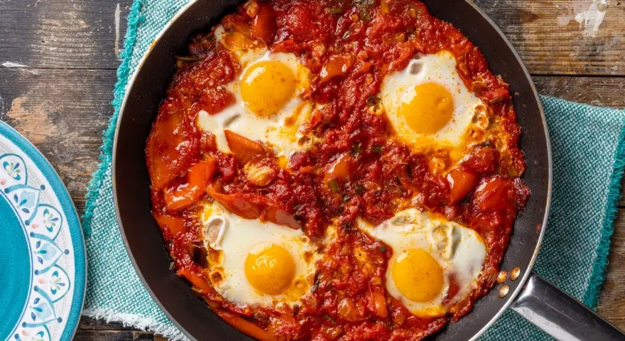 Uova in purgatorio in padella, un classico tra le ricette con uova, con pomodoro e peperoni.
