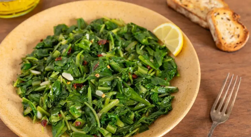 Cicoria saltata con aglio e peperoncino, un modo semplice per imparare come cucinare la cicoria. Servita con pane tostato e limone.