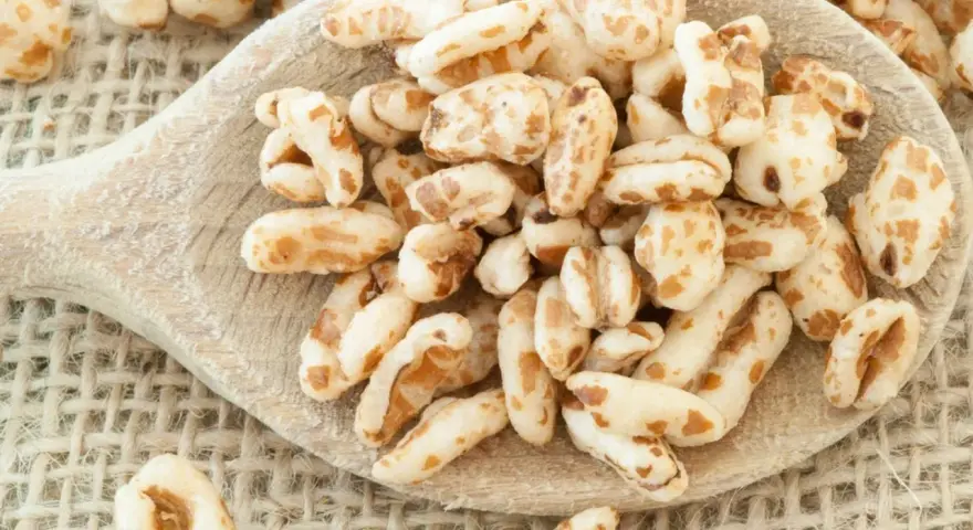 Farro soffiato su un cucchiaio di legno, perfetto per colazioni leggere e ricette creative.