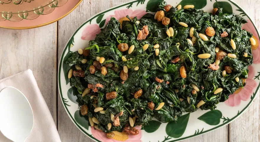 Spinaci saltati con pinoli e uvetta, un modo gustoso per imparare come cucinare gli spinaci.