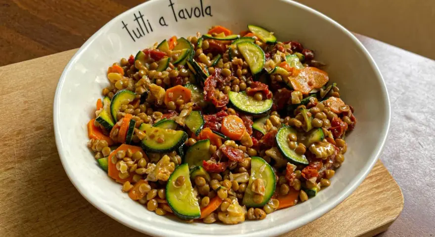 Insalata di lenticchie con zucchine, carote e pomodori secchi, perfetta per le ricette estive.