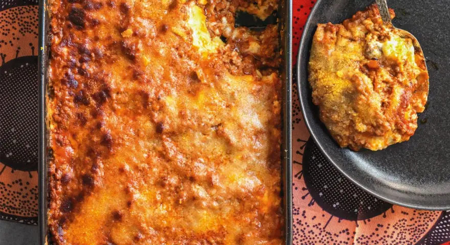 Una porzione di lasagna al ragù appena sfornata, dorata e invitante, pronta per essere gustata.