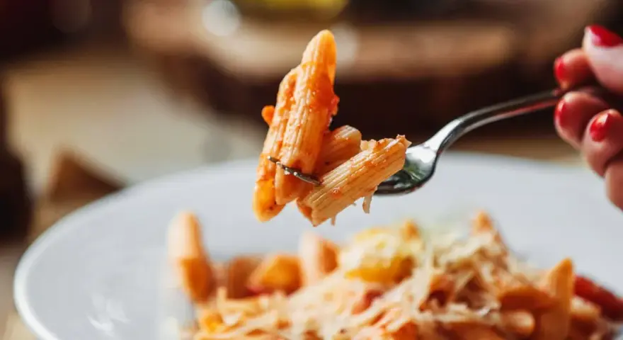 Forchetta con penne al pomodoro, un esempio di sughi per pasta veloci e leggeri.
