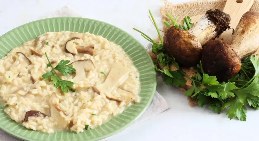 Piatto di cremoso risotto ai funghi, con funghi freschi e prezzemolo a guarnire. Un'ottima alternativa al risotto ai funghi surgelati.