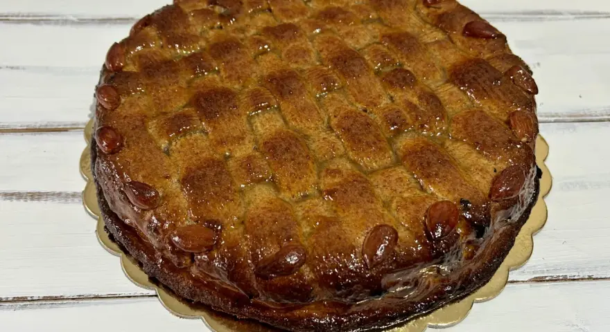 Deliziosa torta di mandorle siciliana, con una crosta dorata e mandorle intere a decorare il bordo.