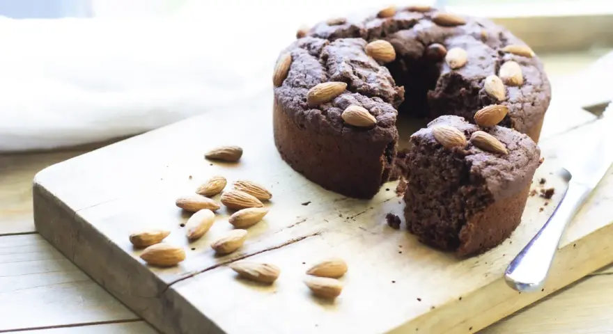 Torta al cioccolato con mandorle, una deliziosa torta con cereali avanzati, su tagliere di legno.