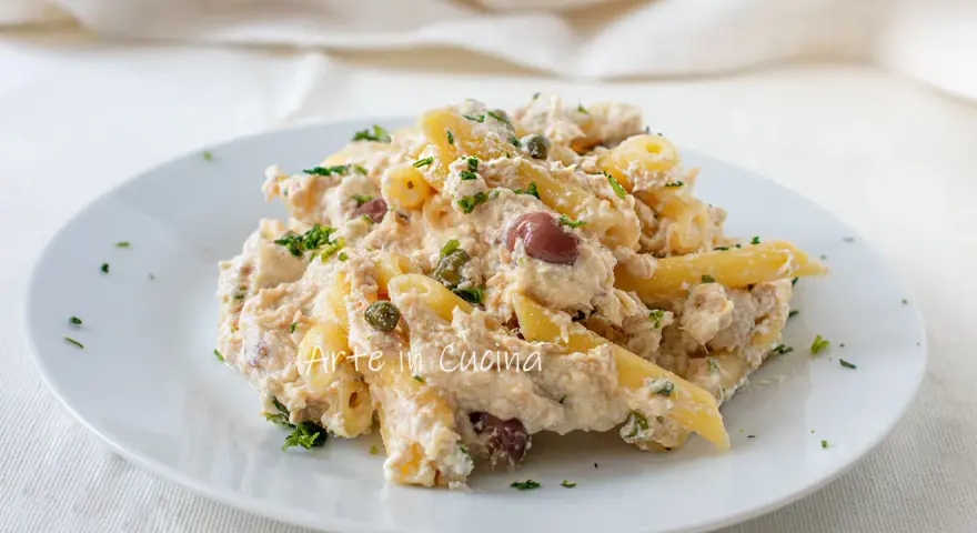 Piatto di pasta cremosa con tonno, capperi e olive taggiasche, guarnito con prezzemolo fresco.