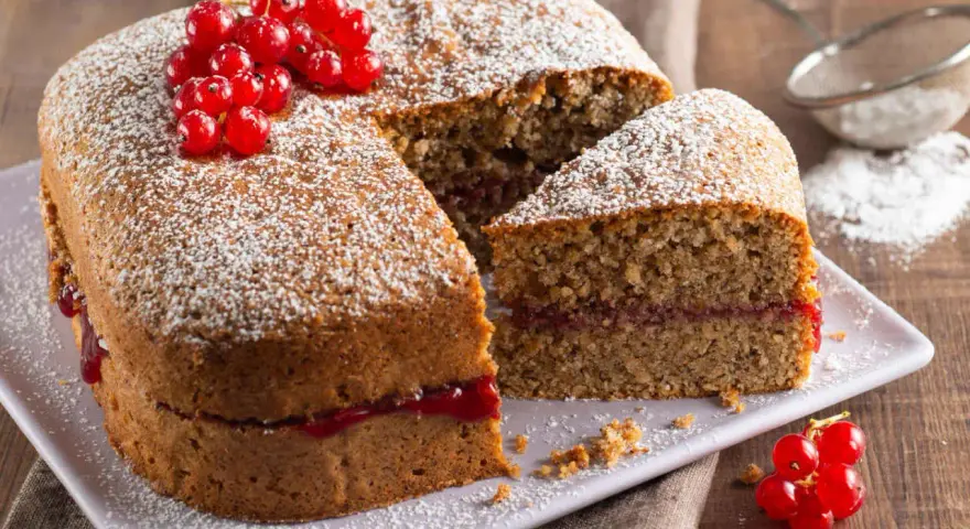 Torta di grano saraceno soffice, farcita con marmellata e decorata con ribes rossi e zucchero a velo.
