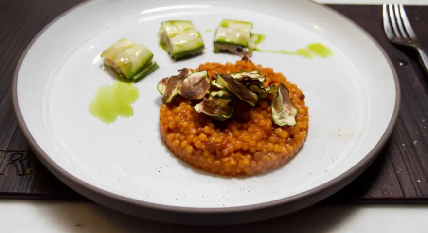 Piatto di fregola sarda ricette con zucchine croccanti e salsa verde. Un primo piatto gustoso e colorato.