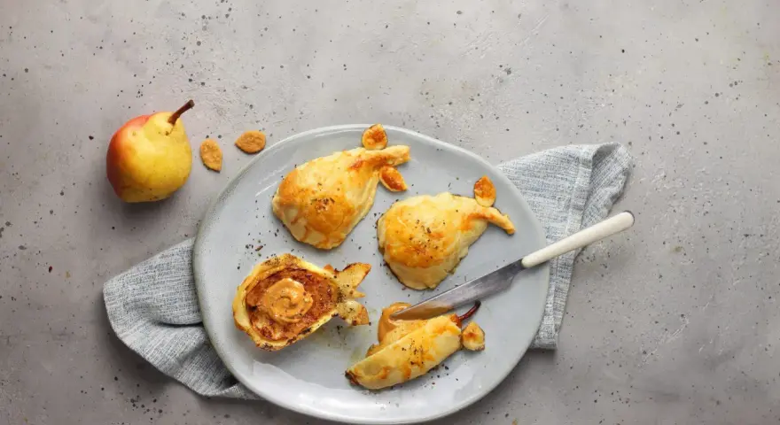 Pasticcini salati a forma di pesce, uno aperto rivela un ripieno cremoso. Un'idea originale per le tue ricette con le pere.