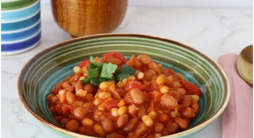 Un piatto invitante di fagioli in umido, con pomodoro e prezzemolo fresco, pronto per essere gustato.