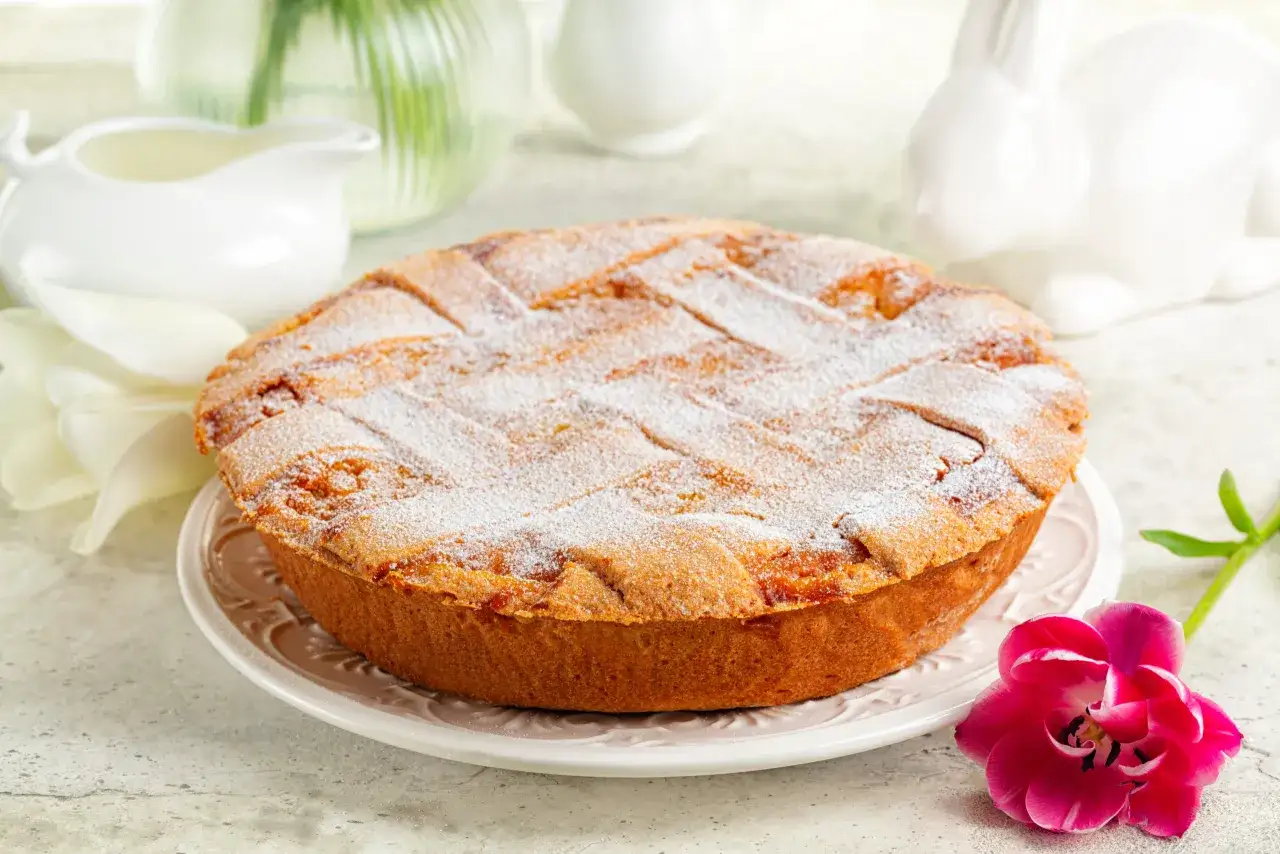 La pastiera napoletana, dolce tradizionale pasquale, spolverata di zucchero a velo, con fiori e coniglietti decorativi.