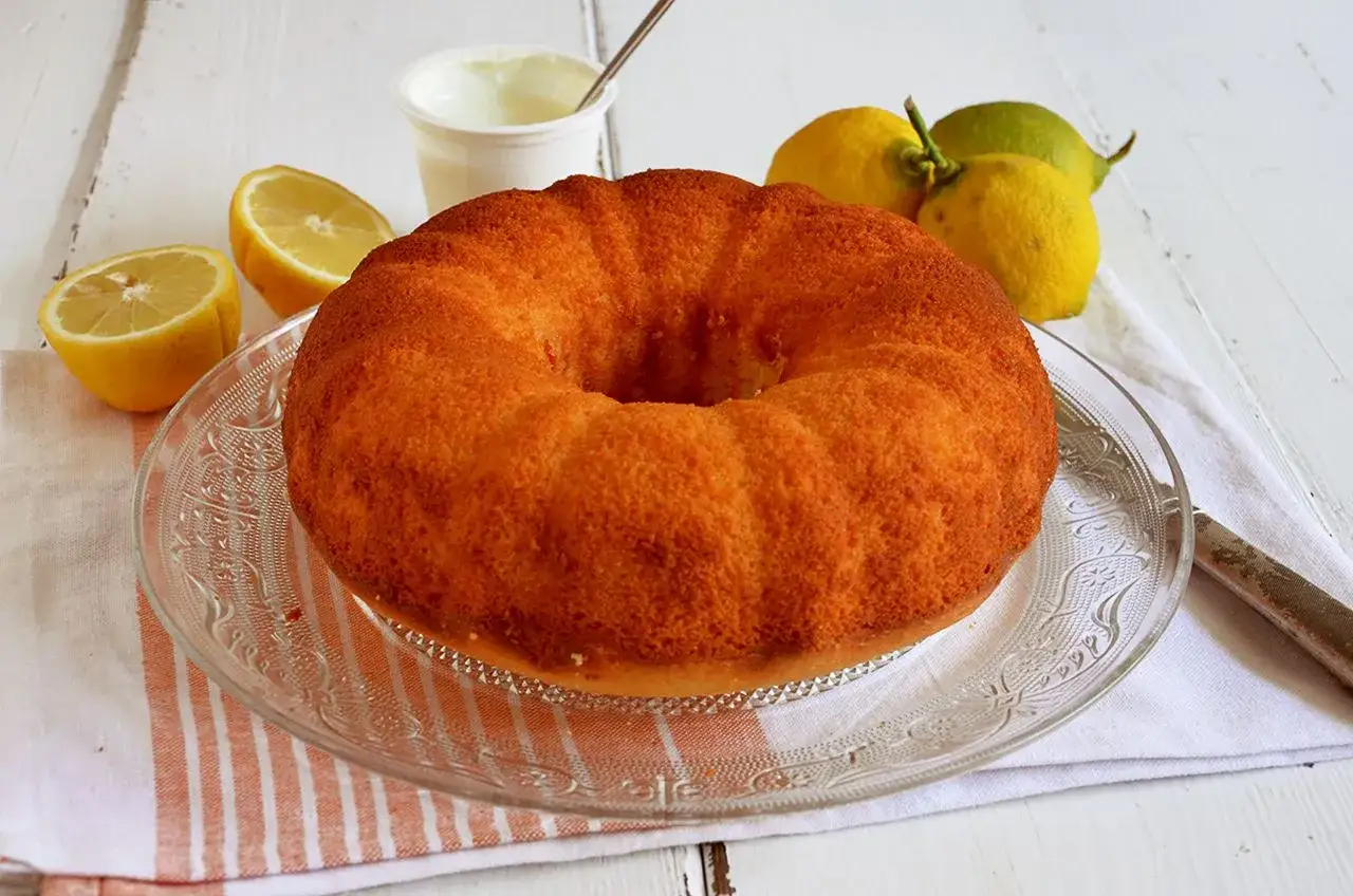 Ciambella soffice allo yogurt greco, profumata al limone, pronta per essere gustata.