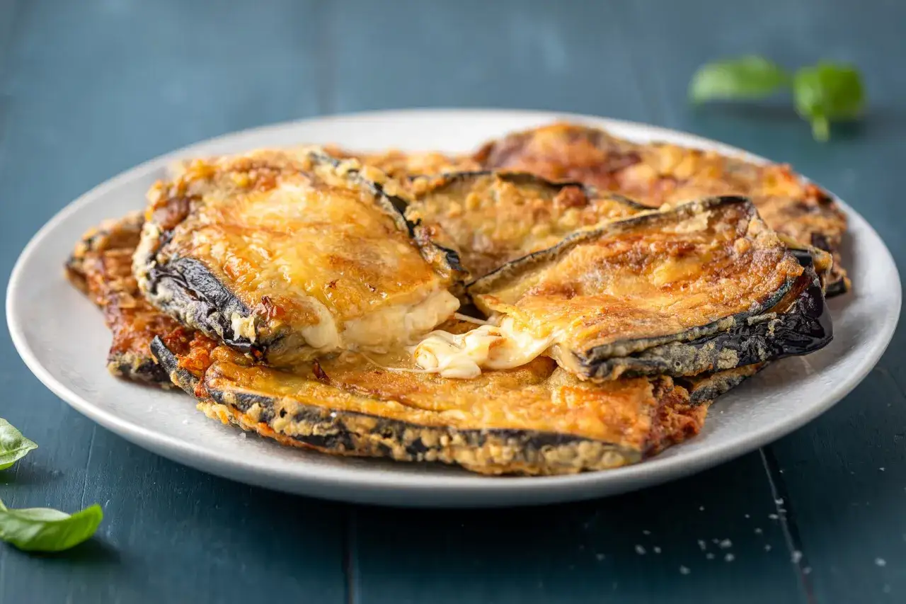 Melanzane fritte e dorate, filanti di formaggio fuso, un assaggio dei 100 modi per cucinare le melanzane.