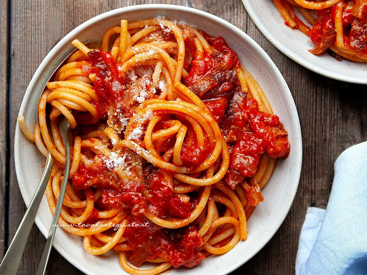 Bucatini all'amatriciana, un classico della cucina romana. La ricetta originale amatriciana cipolla, con guanciale croccante e pomodoro.