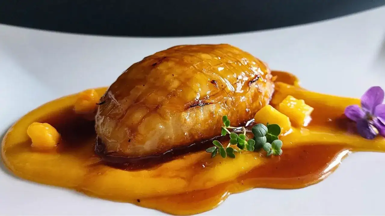 Petto d'anatra glassato su crema di zucca, con cubetti di mango e fiore edule. Un'idea per le tue ricette.