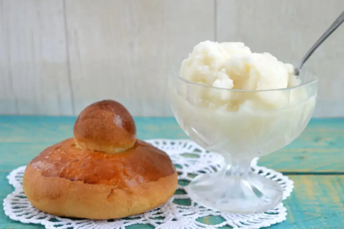 Brioche soffice accanto a una coppa di granita di mandorle, un classico siciliano per una pausa golosa.