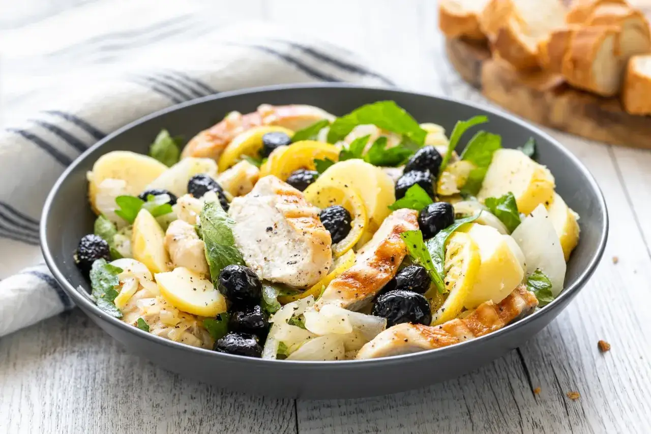 Insalata di pollo con patate, olive nere e limone, un piatto fresco e saporito.