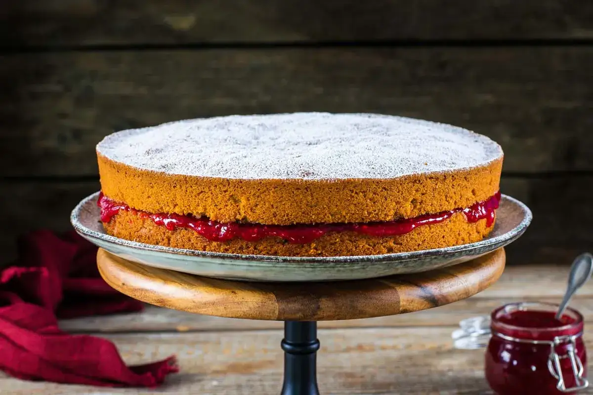 Torta soffice con marmellata di lamponi, ideale per le tue ricette con farina di grano saraceno. Spolverata di zucchero a velo.