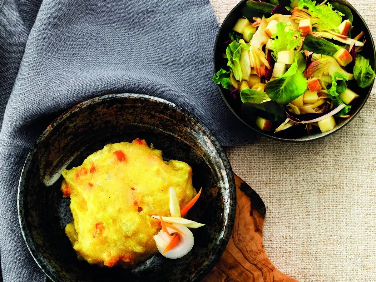 Frittelle dorate con verdure, perfette come contorno per la polenta. Accanto, un'insalata fresca con mele e lattuga.