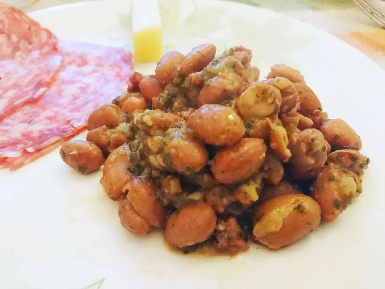 Fagioli in umido, un sapore autentico della ricetta veneta, serviti con salumi e formaggio.