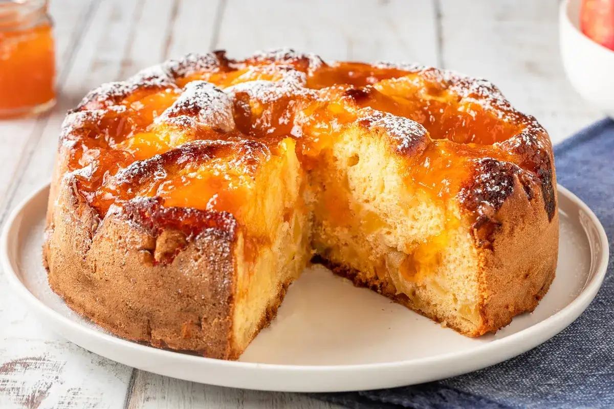 Torta soffice con albicocche sciroppate e zucchero a velo, un dolce invitante.